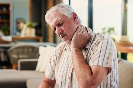 Older adult holding his neck in discomfort