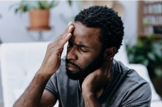 Person holding his head and neck with tension